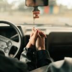 A couple holds hands inside a car, symbolizing love and connection on a journey.