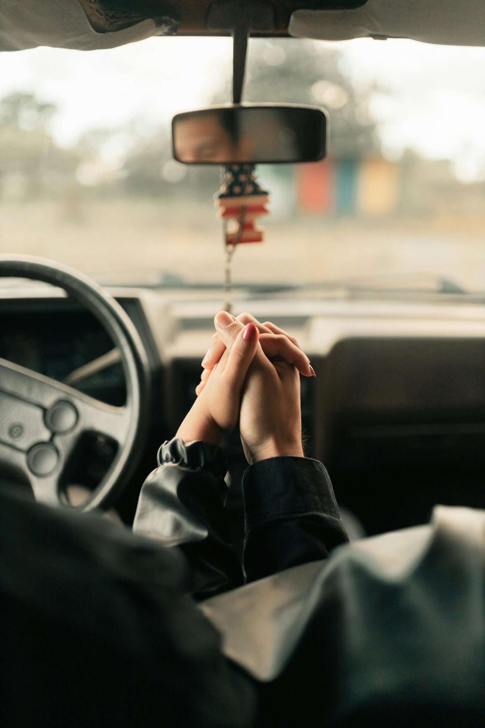 pexels-photo-30020290-30020290 A couple holds hands inside a car, symbolizing love and connection on a journey.